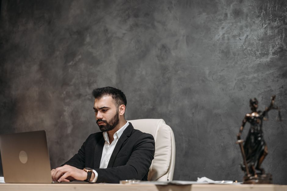 Legal counsel analyzing case on laptop in modern office