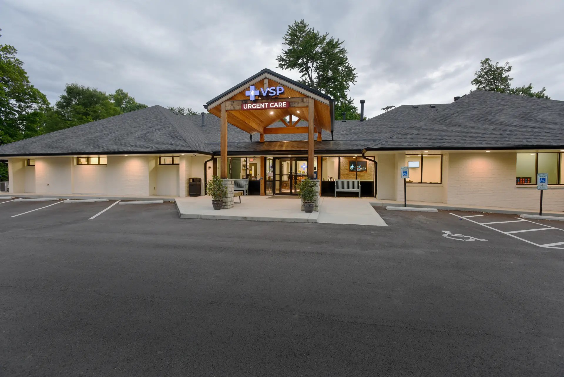 The exterior of VSP and its parking lot at dusk, with warm lights shining on the sign and the exterior walls.