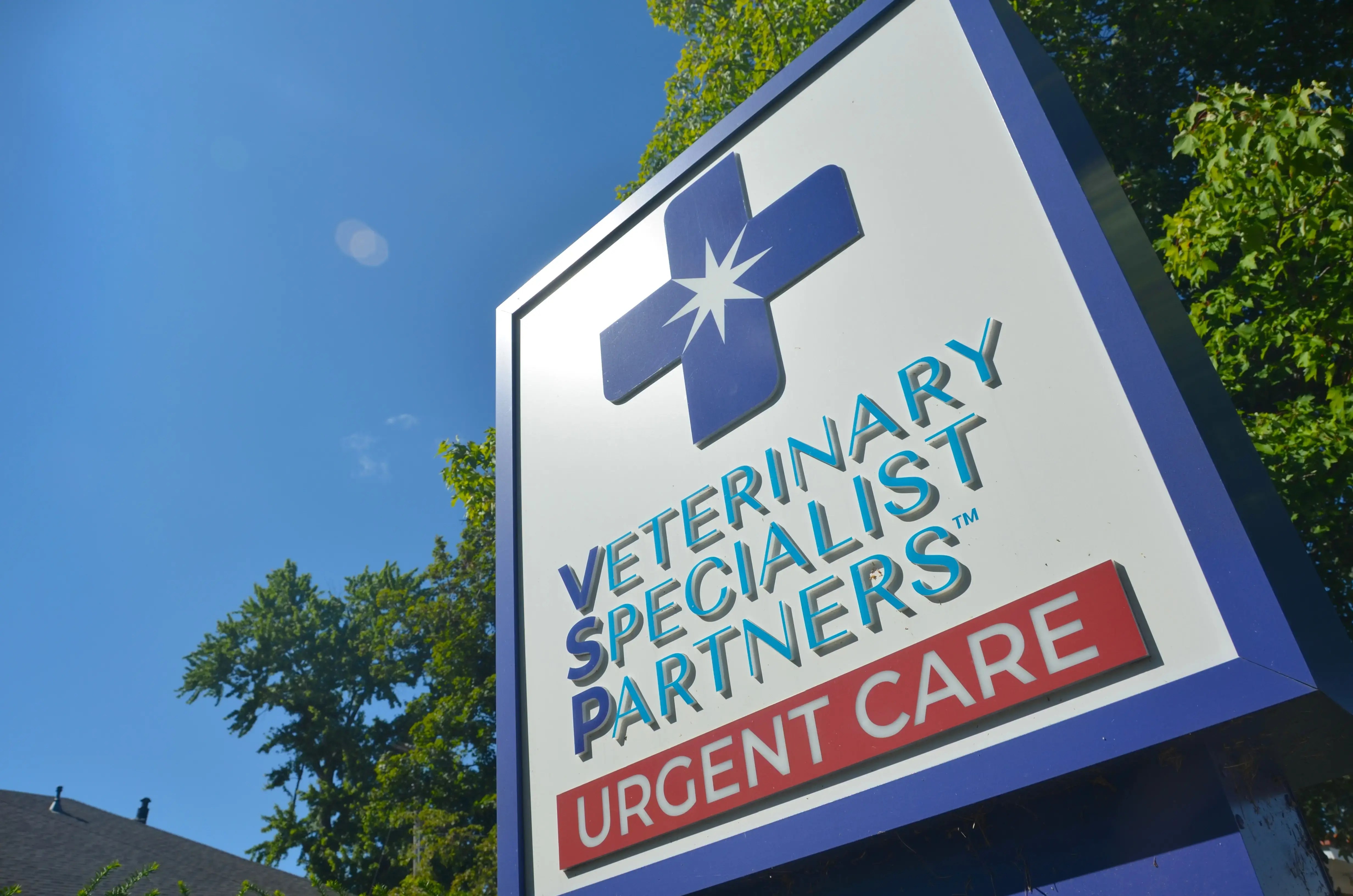 The sign in front of VSP Louisville featuring the logo, set against a blue sky and green trees.