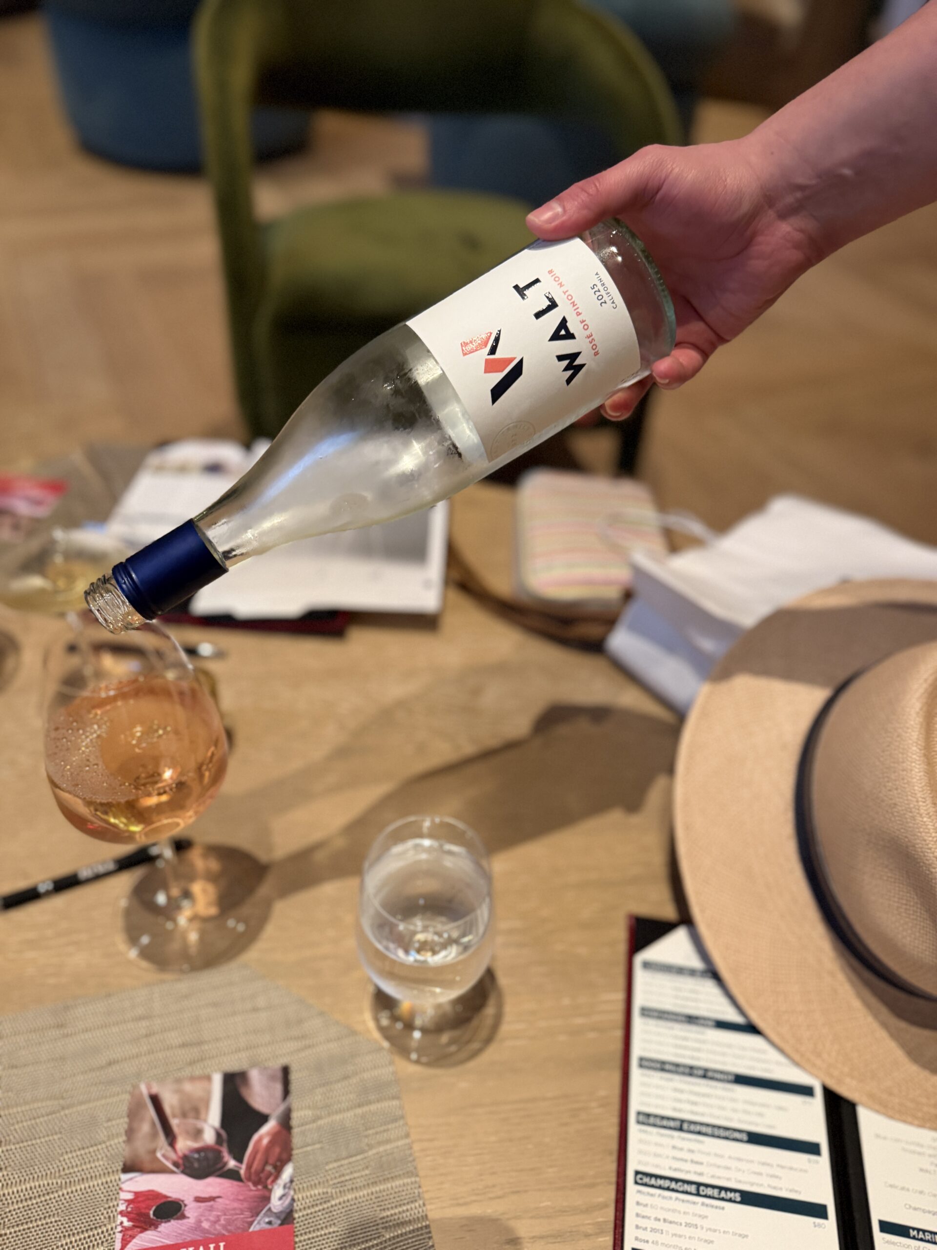 A WALT Rosé of Pinot Noir being poured into a wine glass at a tasting room table.