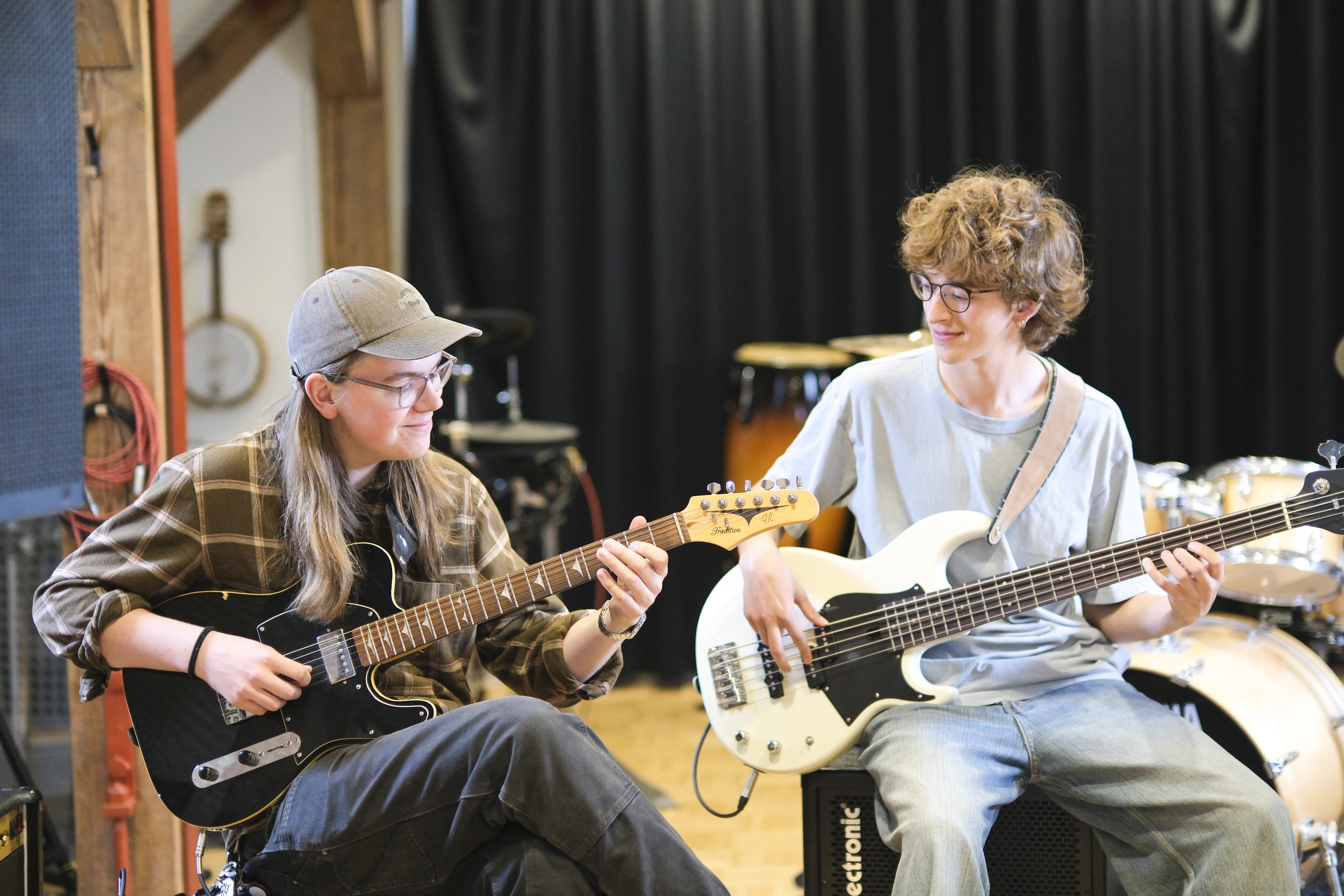 To elever spiller elguitar og bas sammen i musiklokalet