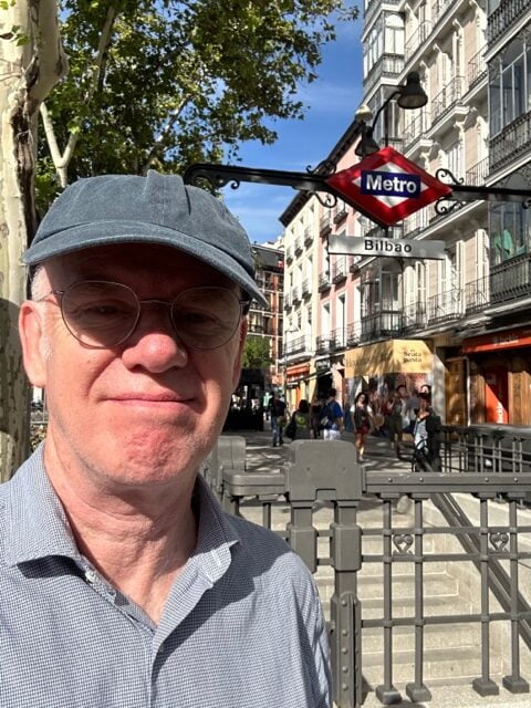 Man taking selfie in front of Bilbao metro station in Madrid.