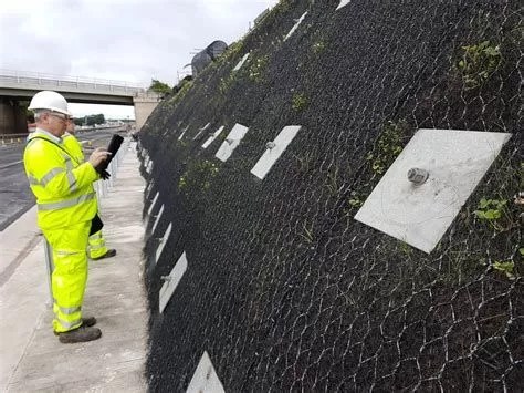 Installation of welded wire mesh and bearing plates for soil nail reinforcement, ensuring slope stability and protection.