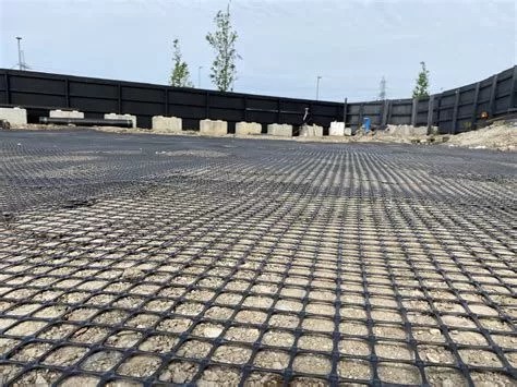 Close-up view of geogrid installation on a construction site, showcasing the mesh-like structure used for soil reinforcement and load distribution.