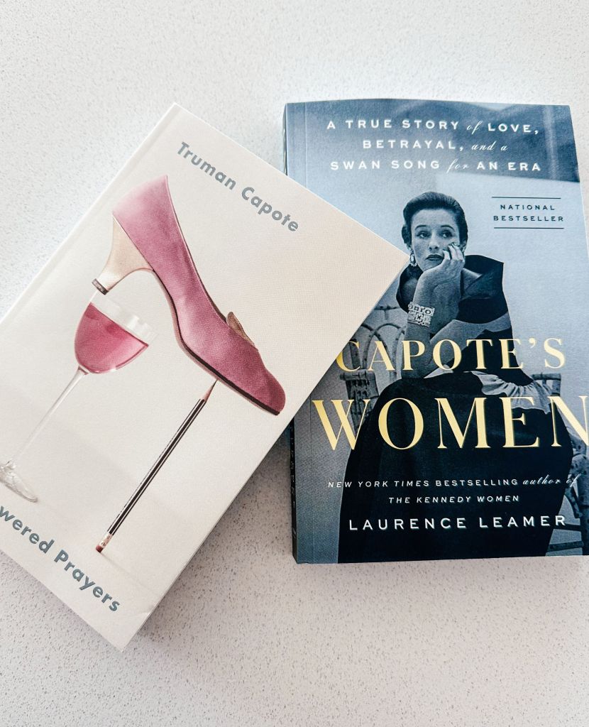 Two books about Truman Capote stacked on top of each other. One has a shoe balanced on a pencil, the other has a woman with her chin in her hand.