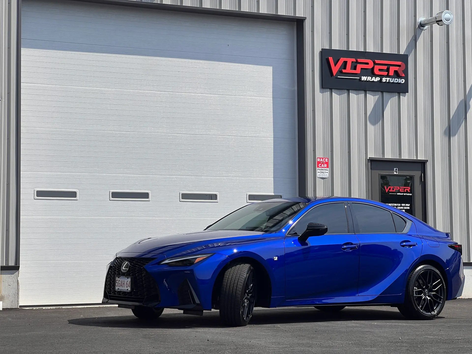 A Ceramic Coated Blue Lexus Sedan Car in front of Viper Wrap Studio,