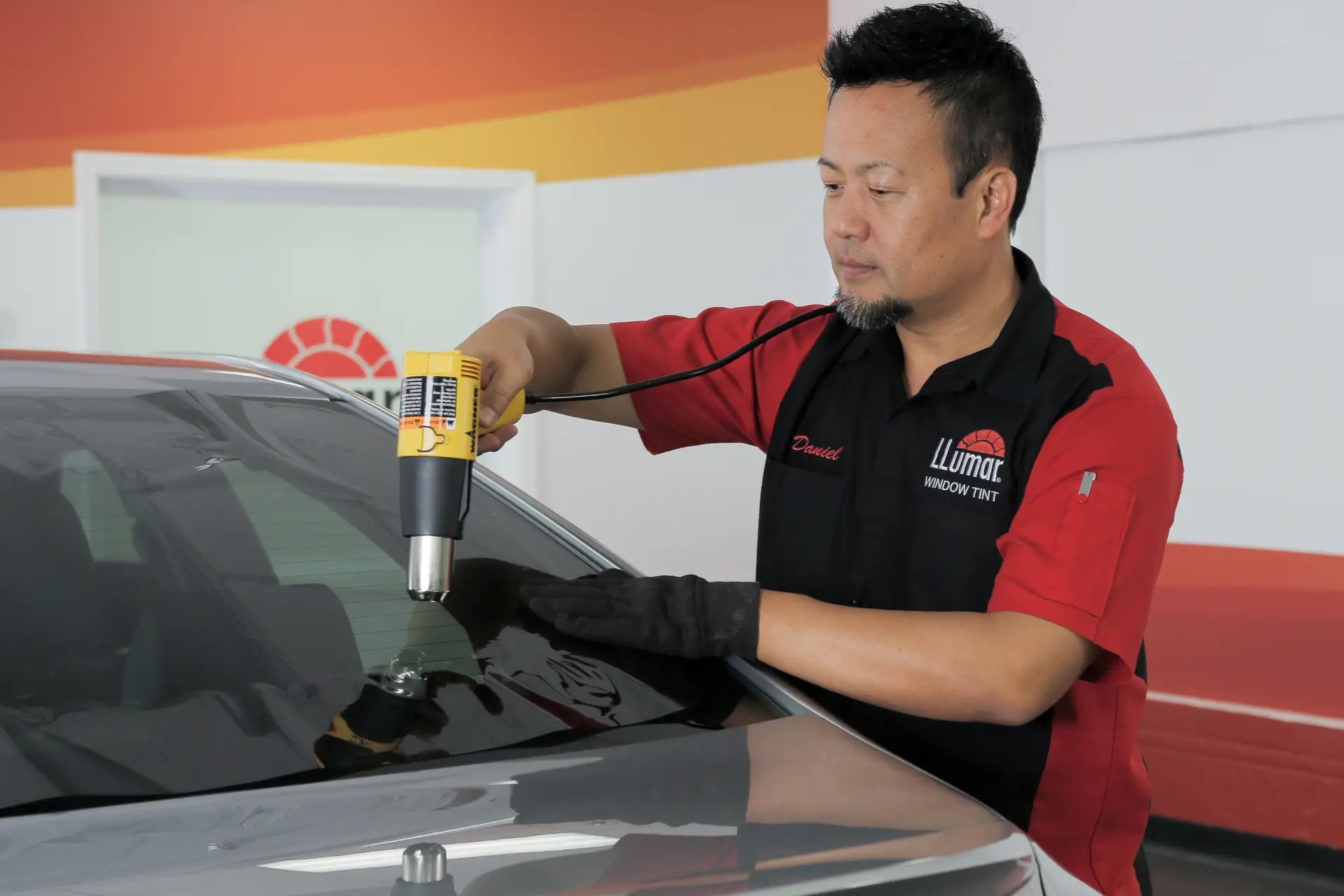 Llumar tech is installing window tint on a car in pembroke ma