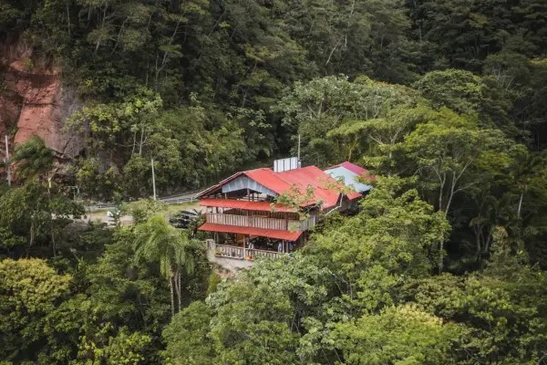 Hospedagem em meio à floresta amazônica com construções de madeira e telhados vermelhos