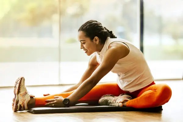 Woman stretching after exercise to support muscle recovery, flexibility, and physical performance