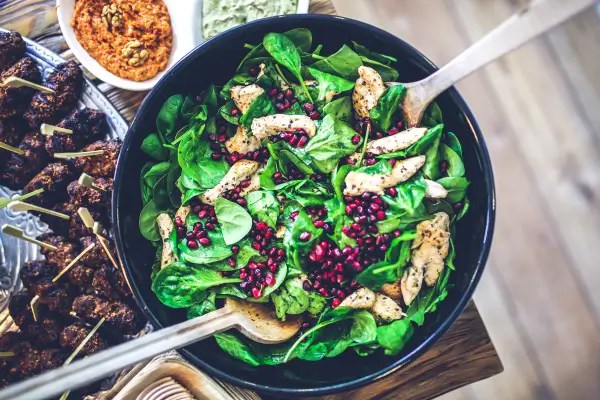 Fresh spinach salad with grilled chicken, leafy greens, and nutrient-rich ingredients representing whole-food dietary sources of magnesium