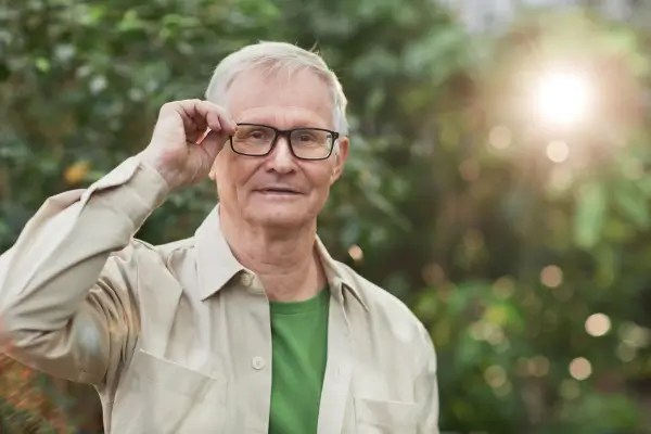 Older adult wearing glasses outdoors representing healthy aging and long-term eye health
