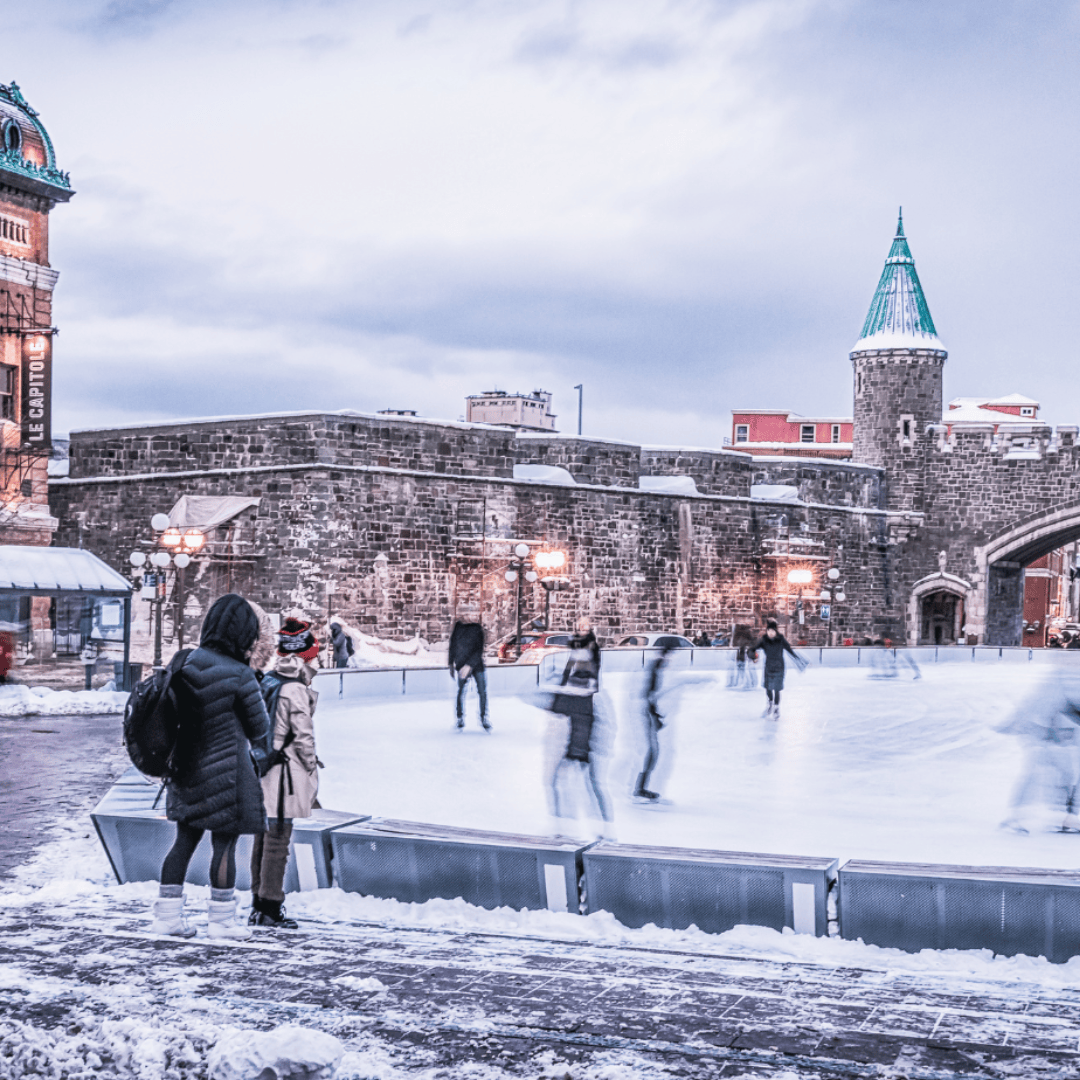 People gracefully skating on an ice rink nestled in front of a captivating st-jean gate in quebec city