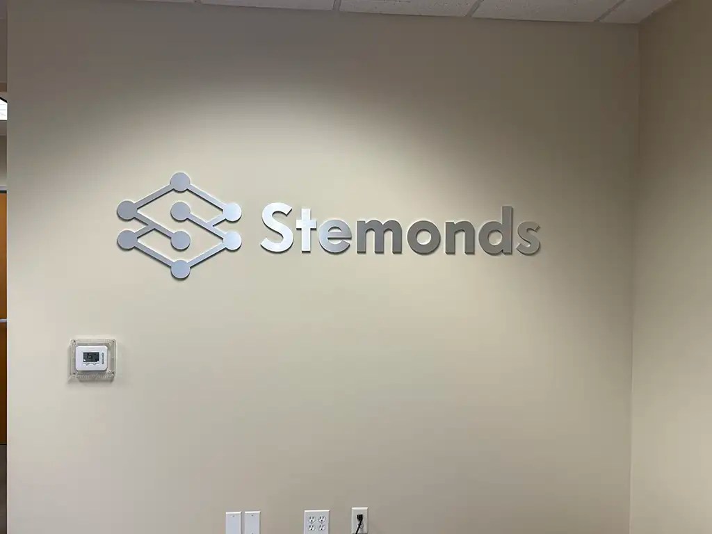Brushed metal lobby sign for Stemonds on office wall in Orange County, California