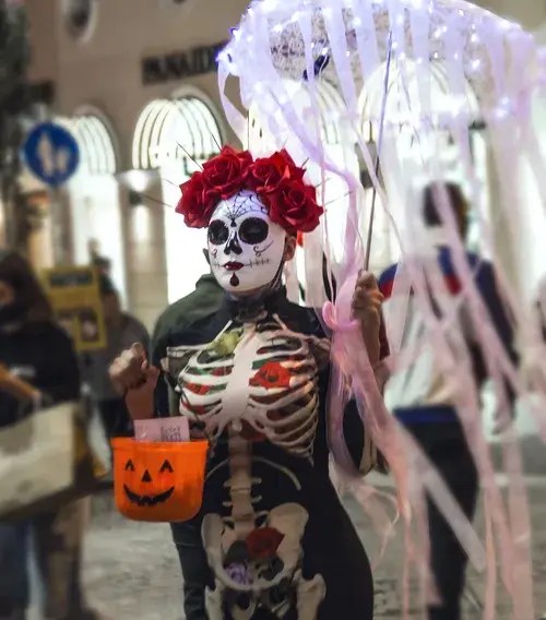 Sugar skull character with LED parasol and pumpkin basket in Athens