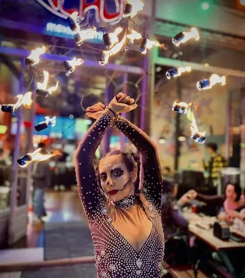Fire fan dancer in Day of the Dead makeup at a Halloween party in Greece