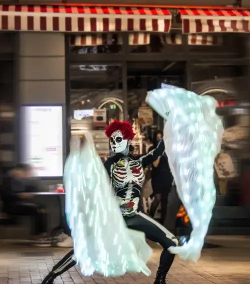 LED skeleton dancer performing with light veils at a Halloween night event