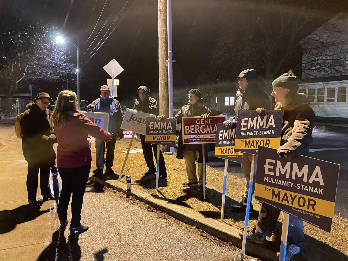 A group of people holding signs on a street at night.