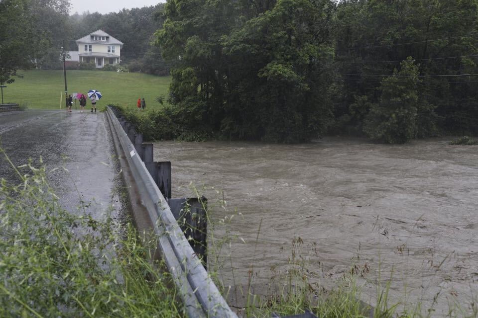 a bridge over a flooded river with people walking on it.