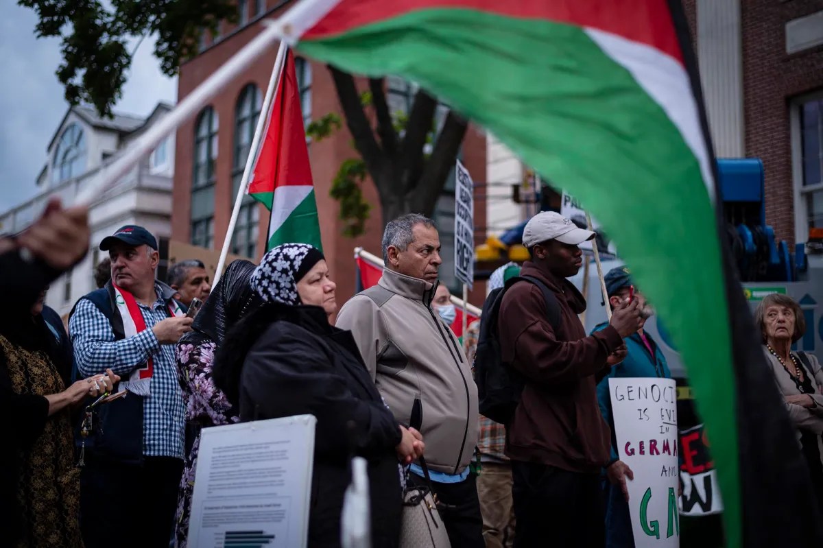 A group of people holding palestinian flags in front of a building.