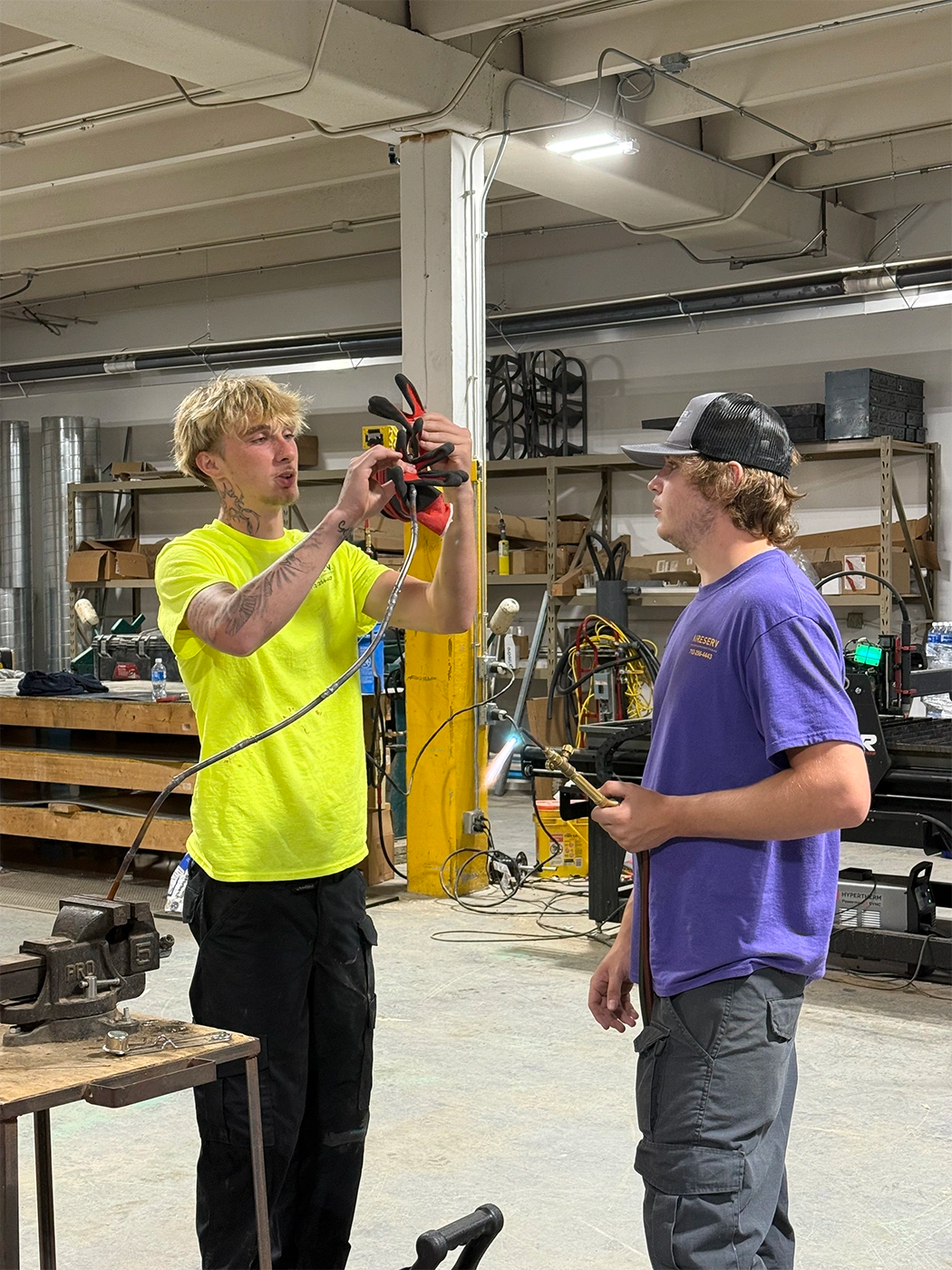 Two men looking at a tool that one of the is holding up