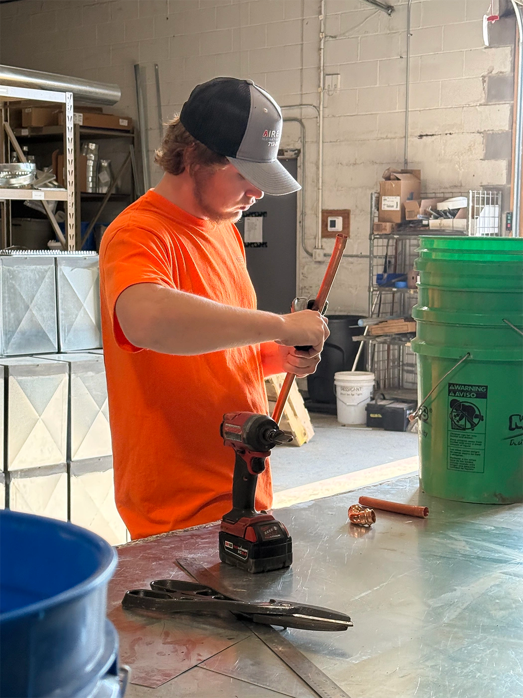 Man next a metal table with tools on it, holding wiring