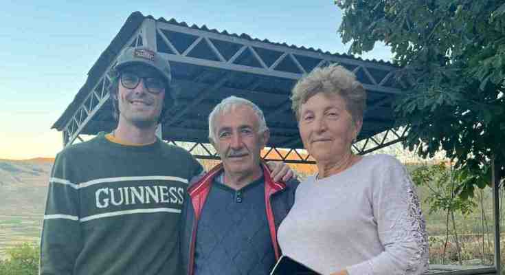 Harry, a US Peace Corps volunteer in Armenia, stands with his two host parents.