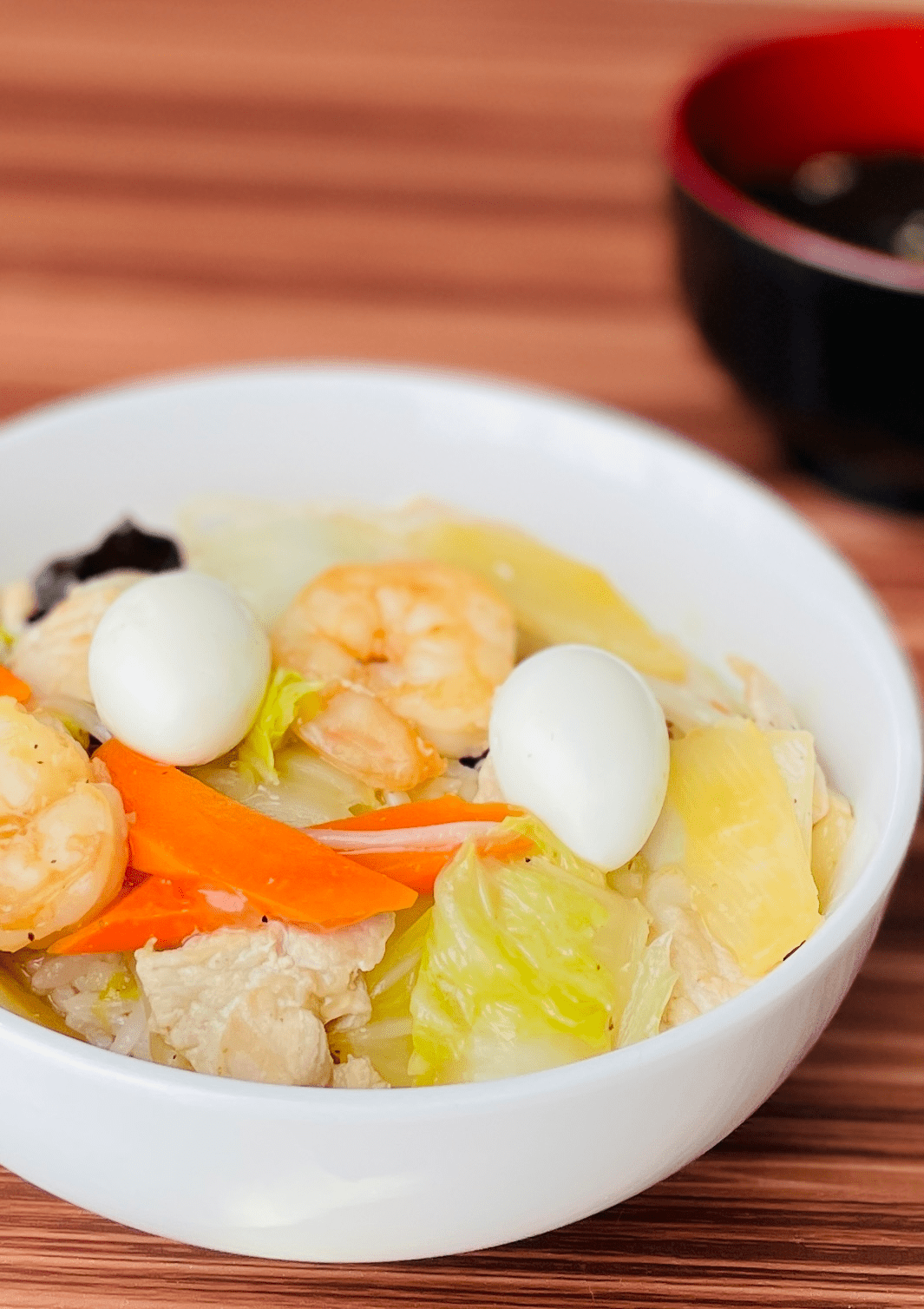 stir fry with pork, shrimp, quail eggs, and colorful vegetables top of the rice