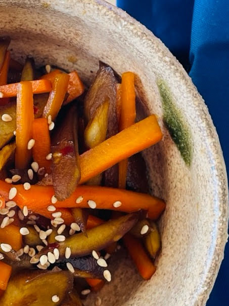 Close-up of Japanese kinpira gobo made with burdock root and carrots, stir-fried in soy sauce and topped with sesame seeds.