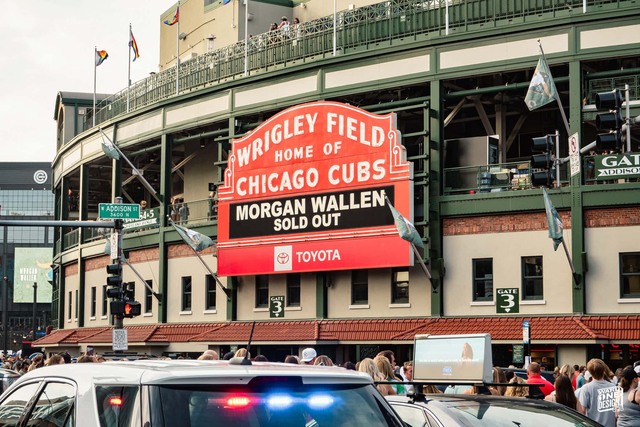 Wrigley Field sign displaying 'Home of Chicago Cubs' and 'Morgan Wallen Sold Out' during a busy day.