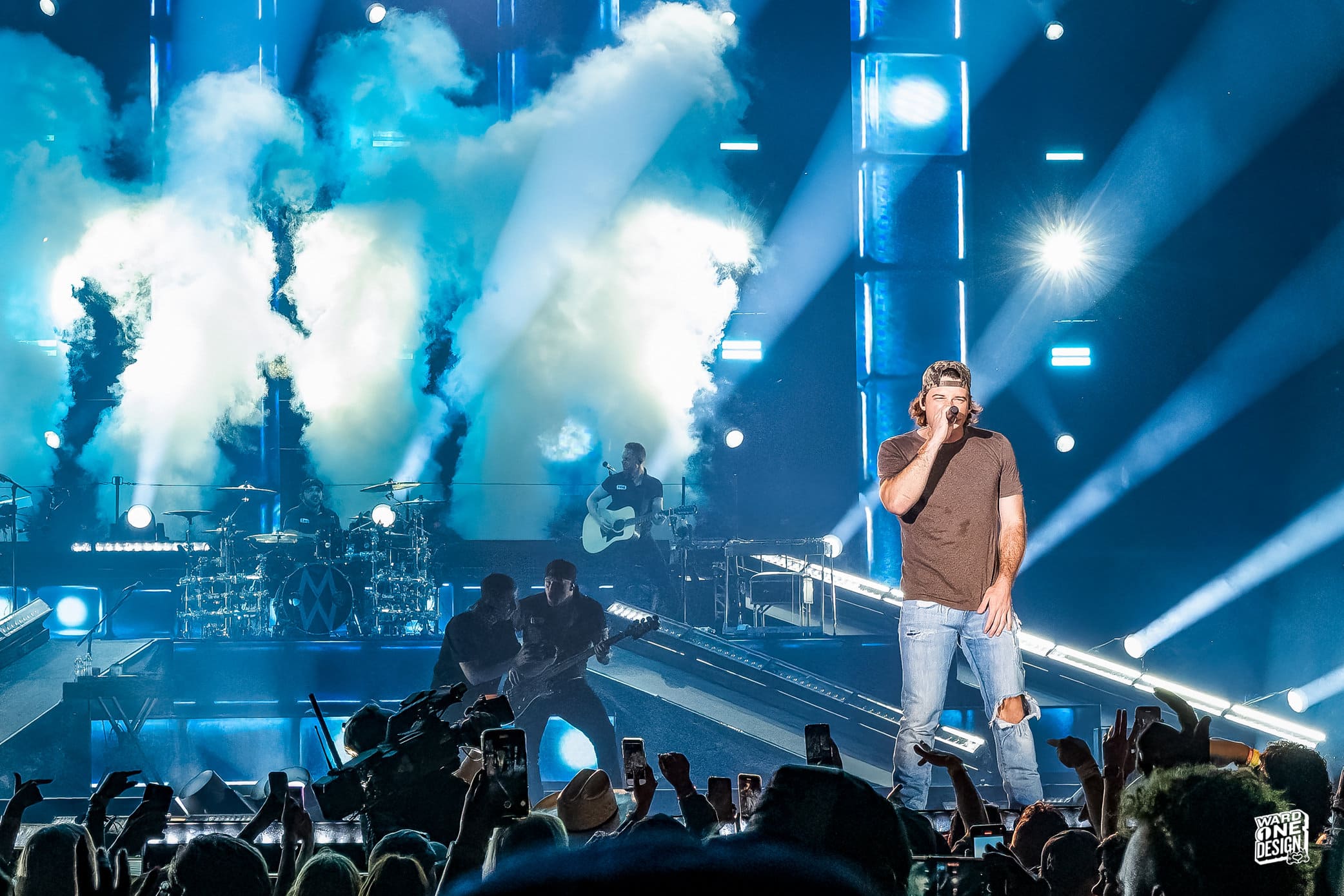 Morgan Wallen performing live on stage during the One Night at a Time Tour with bright stage lights and smoke effects.