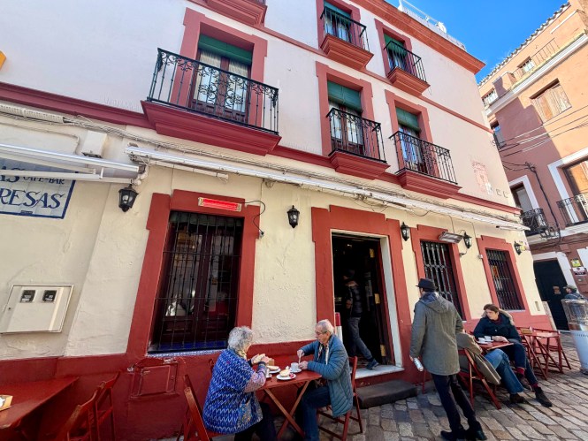 Exterior of Bar Las Teresas in Santa Cruz, Seville, with a couple at an outdoor table