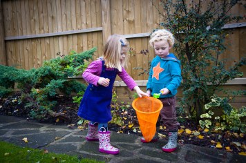 Warm Glow Photo T-9 Twins picking berries with orange net. Photographed at home by Anna Hindocha/Warm Glow Photo