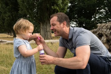 warm-glow-photo-a-8 Toddler girl blowing bubbles with her father in Bushy Park, Teddington in autumn photographed by Anna Hindocha/Warm Glow Photo