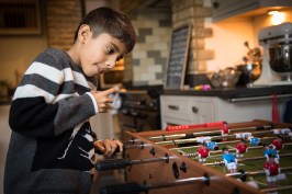 WGP L-351 Boy playing table football lit my ambient light. Photographed by Anna Hindocha/Warm Glow Photo