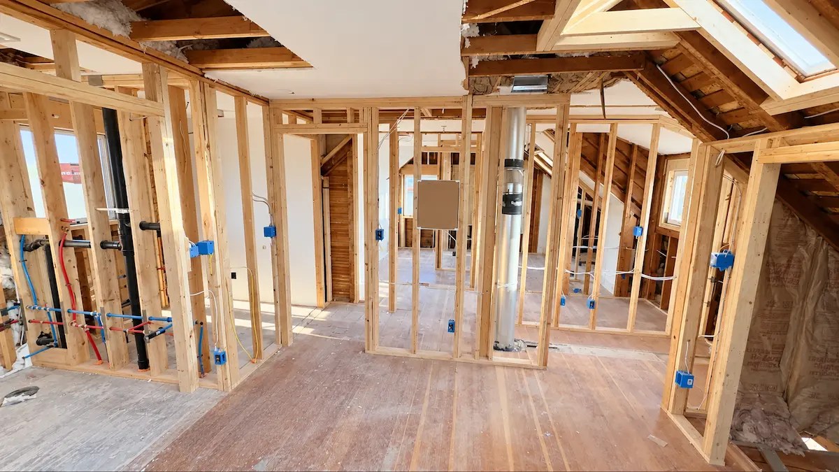 Same room after rewiring, with new cable and blue electrical boxes in the open walls