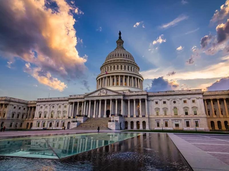 Capitol building against a blue, cloudy sky.