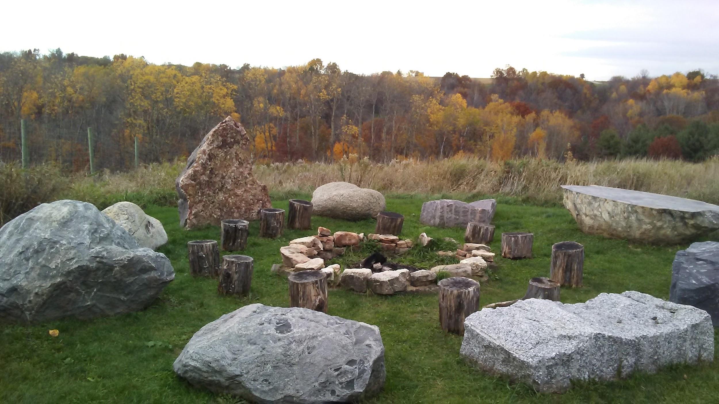 gathering place with rings of stones beside a forest in fall colors