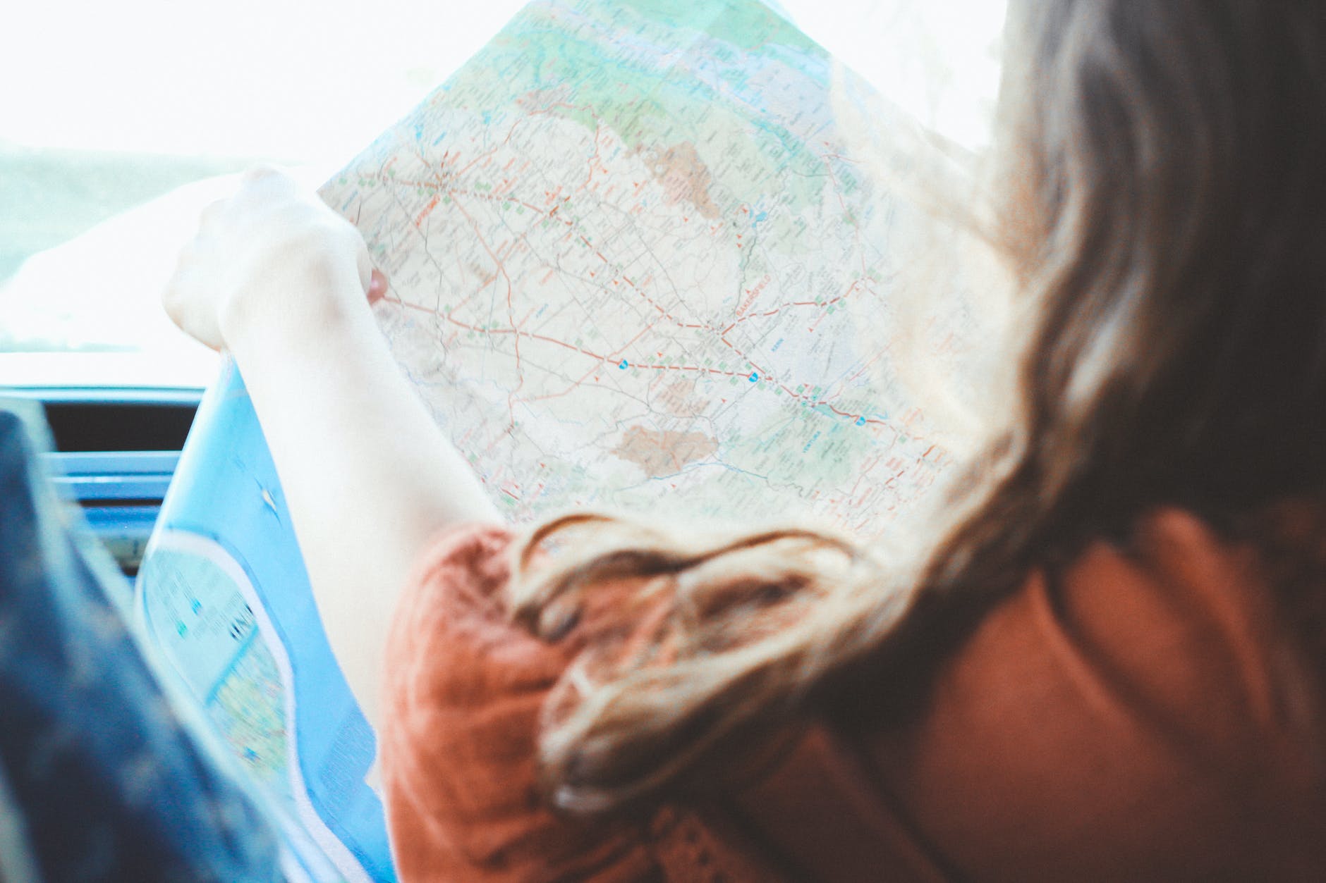 girl holding map inside vehicle