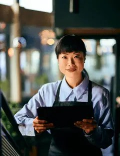 Restaurant manager using a tablet to manage Restaurant365 and integrated financial systems including POS and payroll
