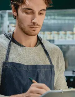 Restaurant operator in apron reviewing structured financial reports to support faster business decisions