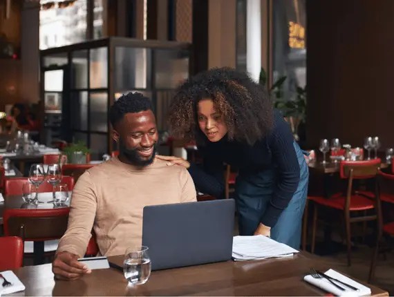 Two restaurant finance professionals working together at a laptop representing common fractional CFO and financial leadership questions TRIS helps restaurant groups answer