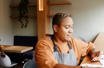 Restaurant operator in apron reviewing operational documents during a TRIS operational discovery and assessment session
