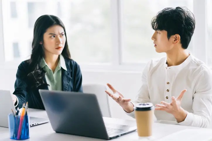 Two young Asian businessmen are debating the year-end project