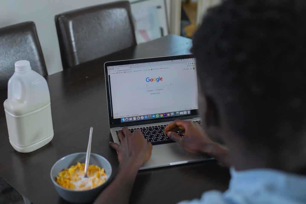 man search on google on his laptop