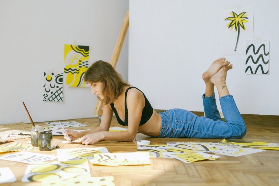 photo of woman lying on floor while painting: Liste de passions hobbies pour femmes