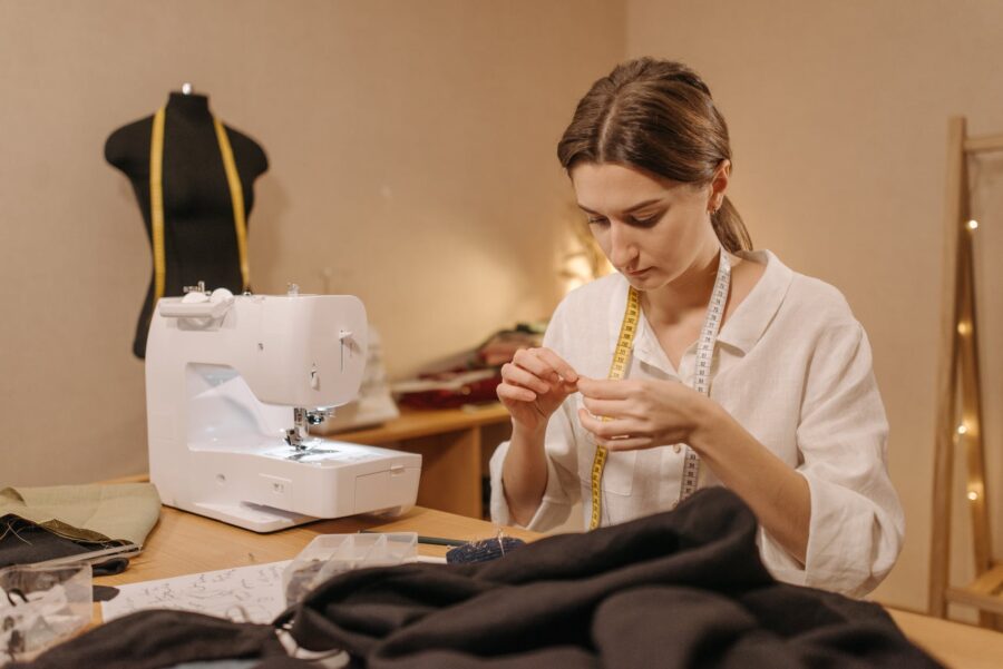 femme en chemise blanche à manches longues en train de coudre