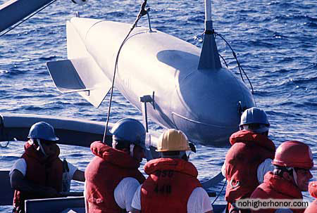 Crew members hoist a minesweeping float, known as a pig, over the side of the ocean minesweeper USS ILLUSIVE (MSO-448) during a training exercise. The ILLUSIVE is one of three minesweepers being towed to the PERSIAN GULF by the salvage ship USS GRAPPLE (ARS-53) to support U.S. Navy escort operations during Operation Earnest Will.