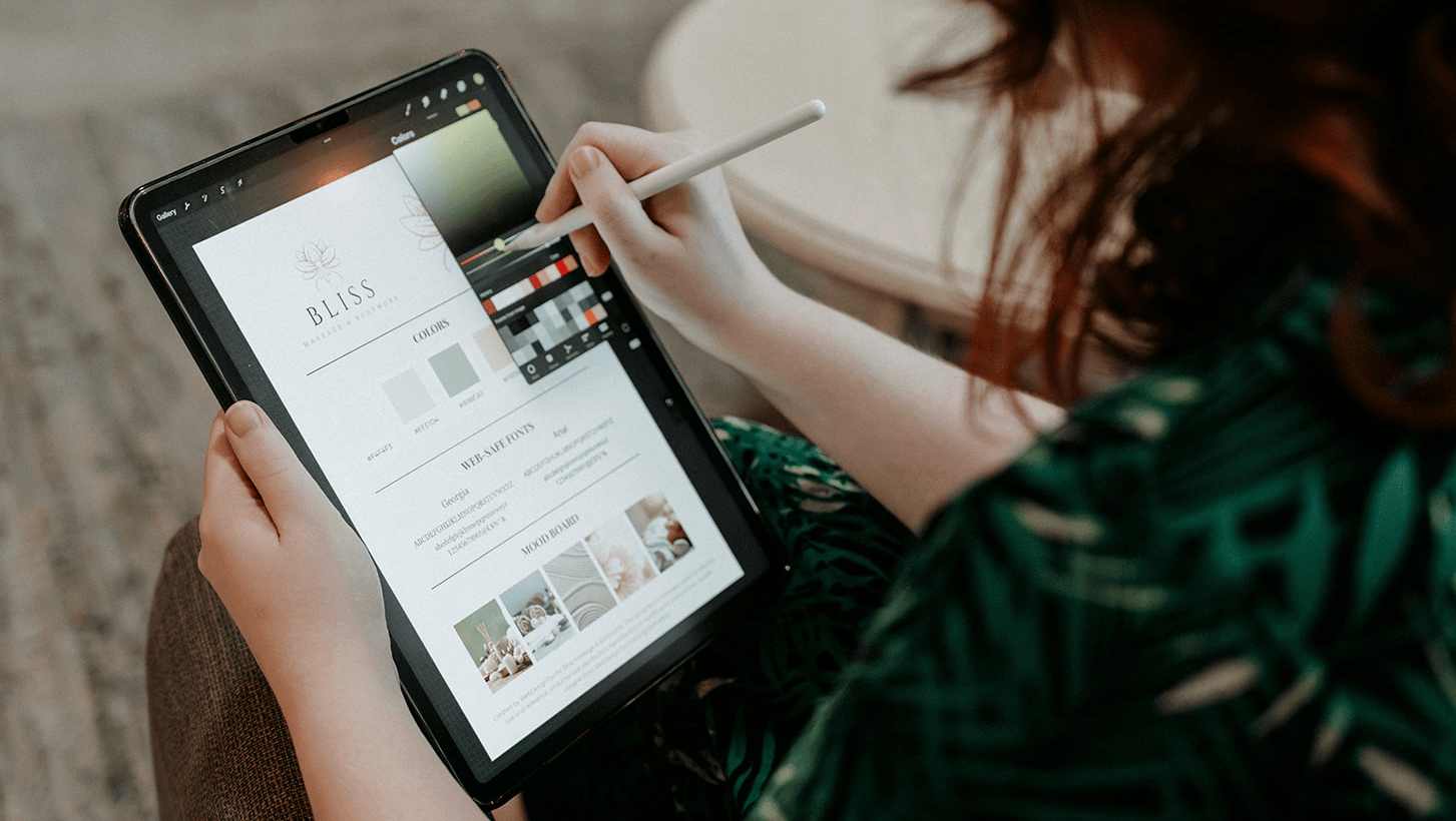 Over the shoulder view of a woman editing a branding guide on her ipad