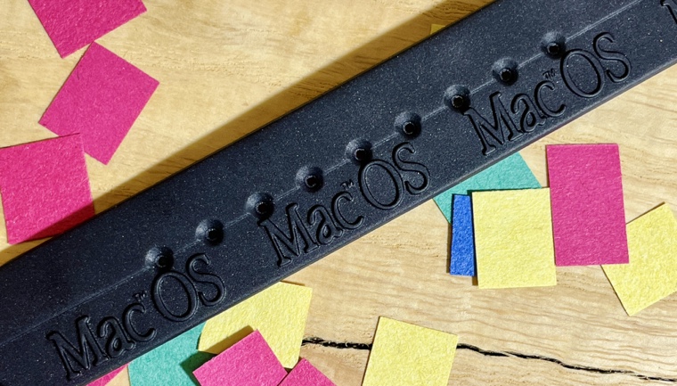 The Apple watch’s band, with the text “MacOS” on it, including a capital letter “M”.