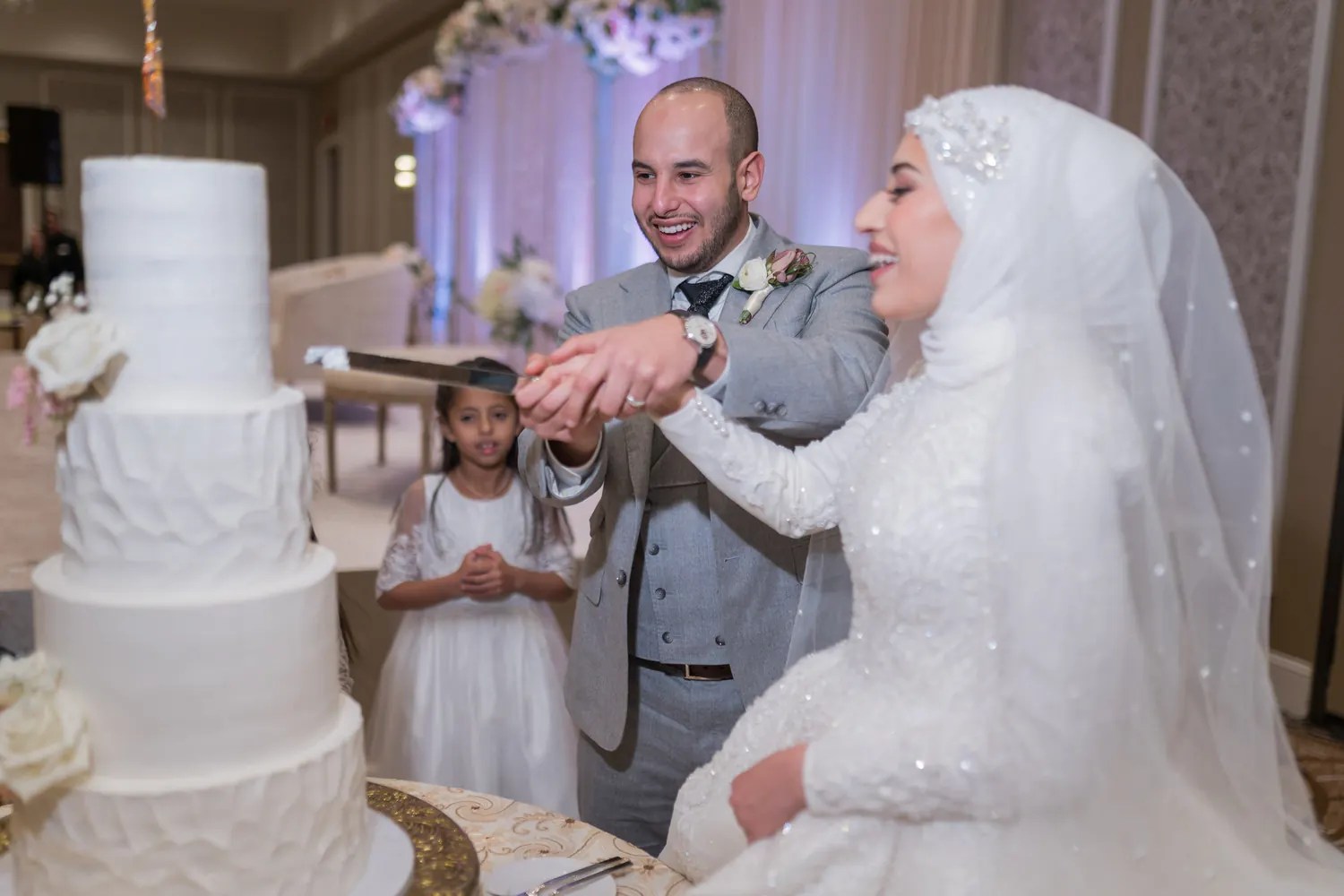 Desi wedding couple cutting their reception cake, photographed by Weddings Unlimited